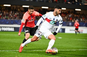 Kylian Mbappé en pleine course avec le ballon lors d'un match de football.