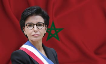 Rachida Dati en portrait officiel avec drapeau marocain en arrière-plan.