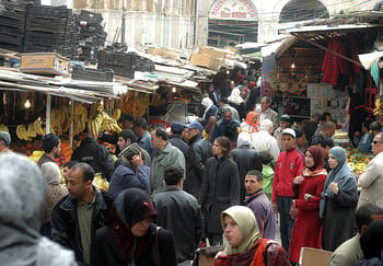 Foule dans un marché algérien avec vendeurs et acheteurs.