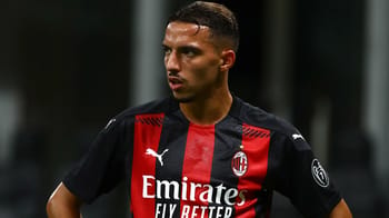 Joueur de football en action portant le maillot de l'AC Milan.