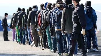 Groupe de migrants en file d'attente pour entrer en France.