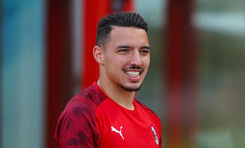 Joueur de football en entraînement avec maillot rouge.