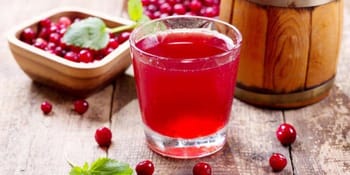Verre de jus de cerise rouge avec cerises fraîches autour.