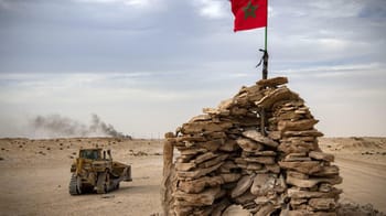 Drapeau du Sahara Occidental sur une structure en pierre dans le désert.