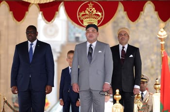 Roi Mohammed VI en costume gris lors d'une cérémonie au Maroc.