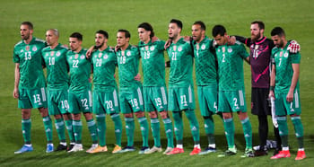 Groupe de joueurs de football en uniforme vert sur le terrain.