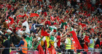 Supporters en délire avec drapeaux algériens et marocains au stade.