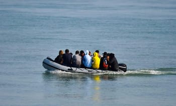 Groupe de migrants à bord d'une petite embarcation en mer.