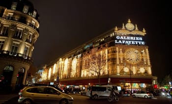 Façade illuminée des Galeries Lafayette à Paris la nuit.