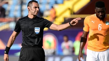 Arbitre FIFA en pleine décision lors d'un match de football.