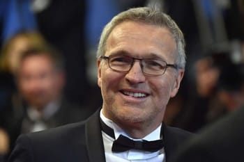 Laurent Ruquier souriant en costume lors d'un événement.