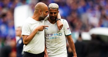 Pep Guardiola parle à Riyad Mahrez lors d'un match de football.