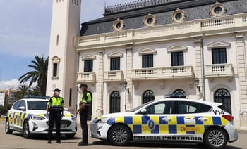 Deux policiers en uniforme discutent devant une voiture de police à Valence.