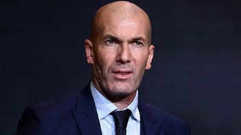 Zidane en Algérie, homme en costume, expression sérieuse.