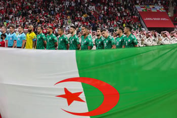 Les joueurs algériens avec le drapeau national en tribune.