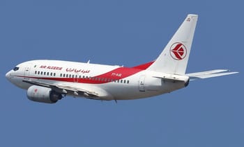 Avion Air Algérie avec logo rouge en vol dans le ciel bleu.