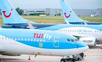 Avions TUI Fly stationnés à l'aéroport avec logo souriant.