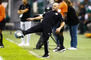 Djamel Belmadi, entraîneur de football, en train de jouer au football sur le terrain.