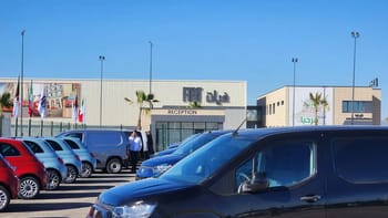 Vue de l’usine Fiat à Oran avec parking et véhicules.