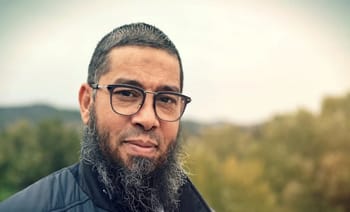 Imam avec lunettes et barbe, contexte extérieur, sujet de l'expulsion.