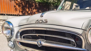 Voiture Peugeot 403 vintage blanche avec grille chromée.
