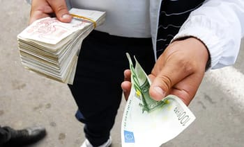Personne vendant des billets de banque en espèces en Algérie.