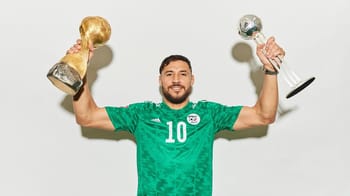 Belaïli célèbre sa victoire avec deux trophées de football.