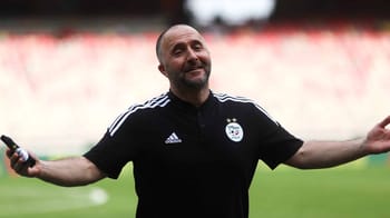 Djamel Belmadi souriant lors d'un match de football.