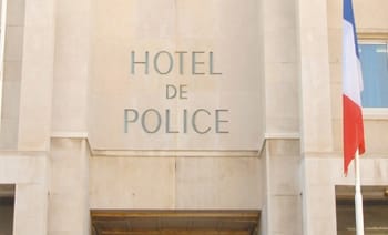 Façade de l'hôtel de police avec drapeau français.