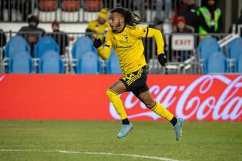 Joueur de football en course sur le terrain lors d'un match.