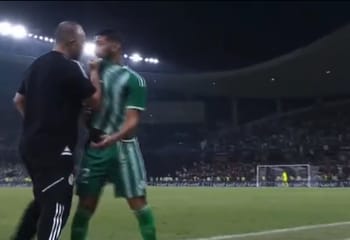 Said Benrahma et Belmadi en conversation sur le terrain de football.