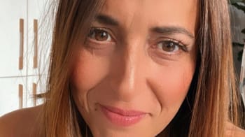 Femme souriante avec cheveux bruns et peau claire.
