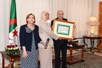 Femme algérienne recevant un prix lors d'une cérémonie officielle.
