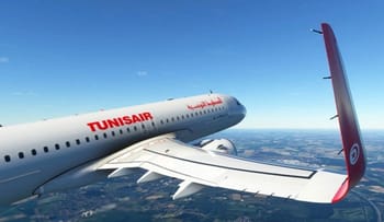 Avion Tunisair en vol avec ciel bleu clair et paysage en dessous.