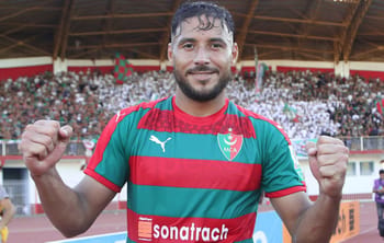 Youcef Belaili, joueur de football algérien, célébrant une victoire.