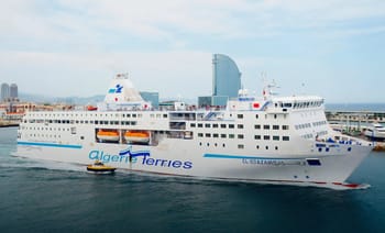 Ferry Algérie Ferries naviguant au port avec la ville en arrière-plan.