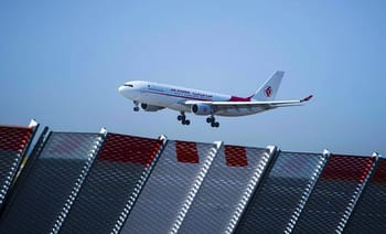 Avion d'Air Algérie en vol au-dessus d'un aéroport.