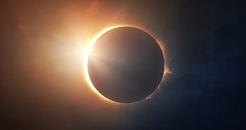 Éclipse solaire totale avec couronne visible et soleil en arrière-plan.
