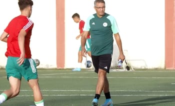 Entraîneur de football donnant des instructions lors d'un entraînement.