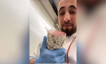 Boucher musulman tenant une pièce de viande de porc dans un laboratoire.