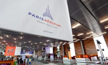 Zone d'enregistrement à l'aéroport de Paris avec comptoirs et écrans.