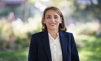 Femme politique souriante en extérieur, portrait professionnel.