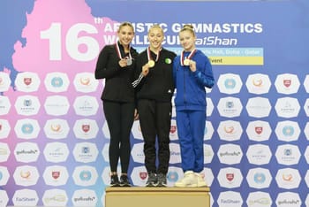 Trois gymnastes sur le podium avec médailles d'or, d'argent et de bronze.