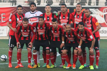 Groupe de joueurs de l'USM Alger en uniforme lors d'un match.