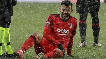 Rachid Ghezzal en tenue de football, blessé sur le terrain sous la pluie.