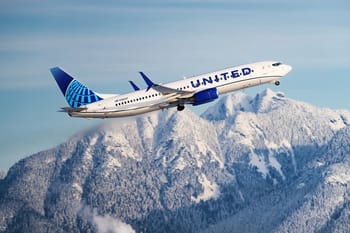 Avion United Airlines survole des montagnes enneigées.
