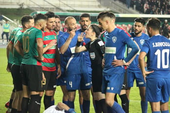 Joueurs de football en dispute lors d'un match sur le terrain.