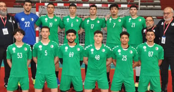 Groupe de joueurs de football algériens en tenue verte lors d'un match.
