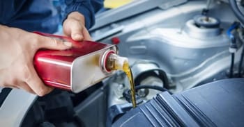 Remplissage d'huile moteur dans un véhicule avec une canette.
