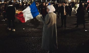 Femme tenant un drapeau français lors d'un événement au stade de Lyon.